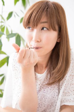 Asyalı kadın evde yemek yiyor. 