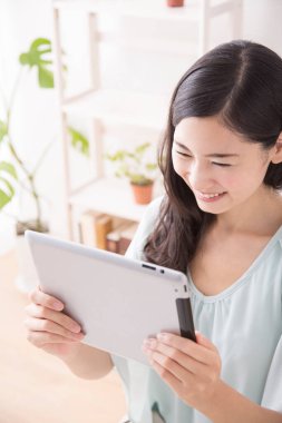 Asyalı kadın evde tablet kullanma 