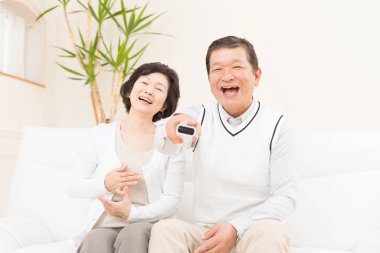 Kanepede oturan Asyalı çift.