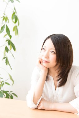 Masada oturan Asyalı kadın rüya görüyor.