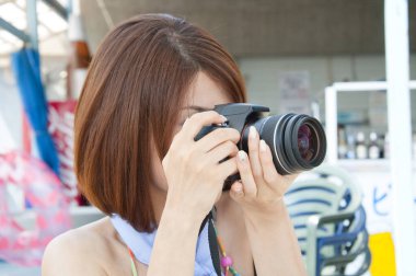 Kameralı kadın fotoğraf çekiyor.
