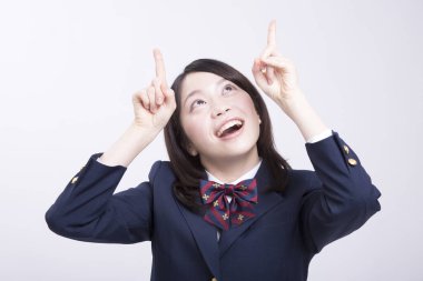 Üniformalı gülümseyen Japon öğrencinin stüdyo portresi.