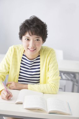 Sınıfta gülümseyen genç bir kadının portresi.