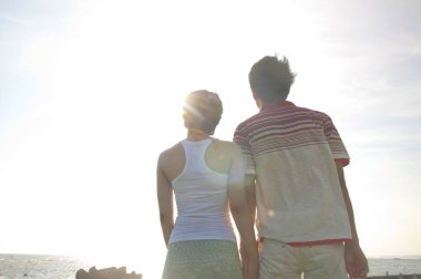 Mutlu Asyalı genç çift deniz kıyısında iyi eğlenceler.