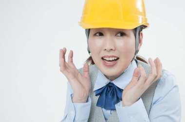 Miğferli, korkmuş Asyalı kadın inşaat işçisi