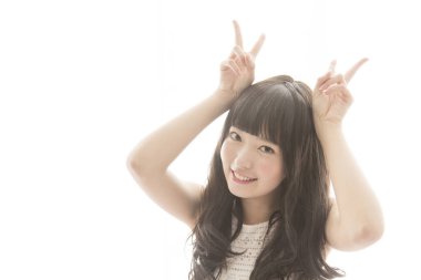 Genç Asyalı kadın boynuzlarını gösteriyor.