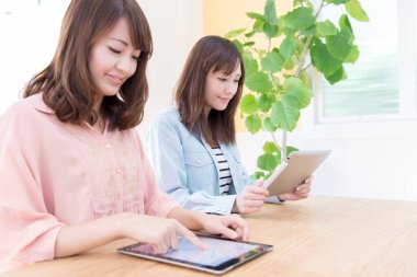 Genç Asyalı öğrenciler sınıfta tablet kullanıyorlar.