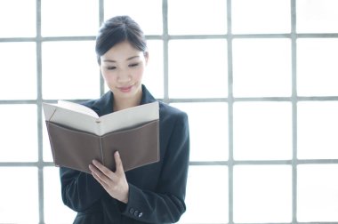 Ofiste kitap okuyan kadın. 