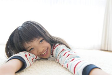 Asyalı kız oturma odasında halıya uzandı.