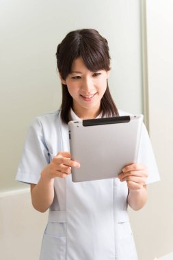 Tablet kullanan Asyalı kadın doktor