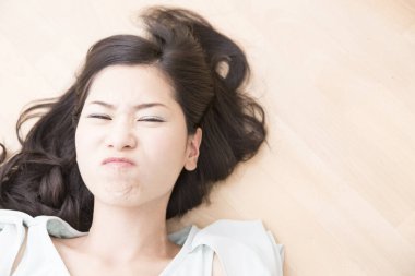 Yerde yatan üzgün Asyalı kadının portresi.