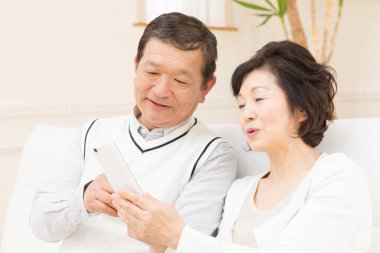 Evde akıllı telefonları olan yaşlı bir çift.