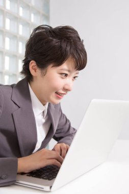 Laptop kullanan genç Asyalı kadın.