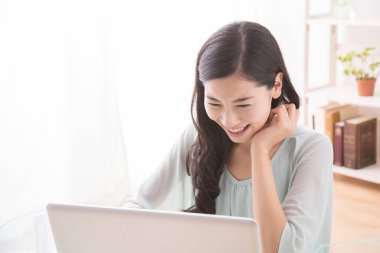 Bilgisayar kullanan Asyalı genç kadın. 