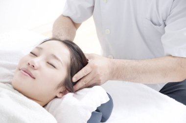 Asyalı kadın kafa masajı yaptırıyor.