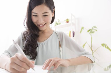 Genç, güzel Asyalı kadın ofiste çalışıyor.