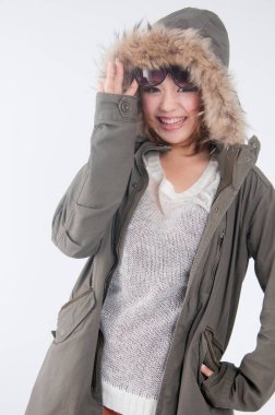 Kapüşonlu genç bir kadın ve yüzünde gülümsemeyle kameraya bakıyor. yüksek kaliteli fotoğraf