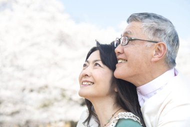 Güzel Asyalı olgun çifti ağaçlarla parka kapatın.