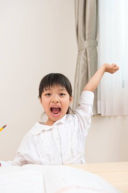 Küçük Asyalı kız ödevini yapıyor. 