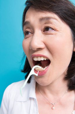 asian woman  using dental Floss pick  