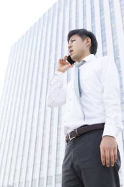 Sokakta cep telefonu olan bir işadamı. 