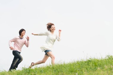 Mutlu genç Asyalı çift yaz parkında koşuyor