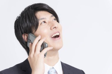 Asyalı işadamı akıllı telefondan konuşuyor 