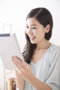 Asyalı kadın evde Tablet PC'yi kullanma