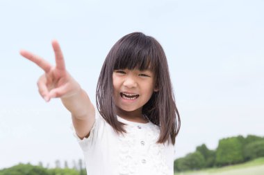 Yaz parkında yürüyen tatlı bir Japon kızı, açık havada eğlenen komik bir çocuğun gündüz portresi.