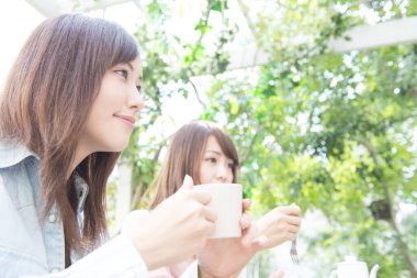 asian women with  cups of tea in the garden