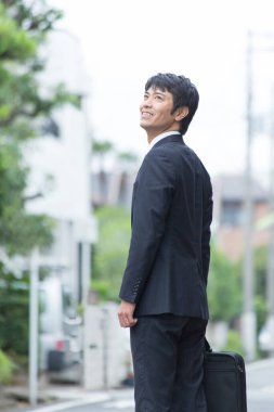 Şehirde evrak çantalı Asyalı işadamı