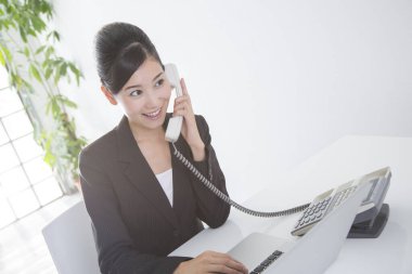 Güzel genç Japon iş kadınının portresi. Telefonla konuşan, beyaz tenli.