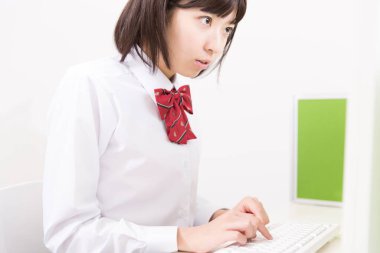 Bilgisayarla çalışan genç bir Japon öğrenci.