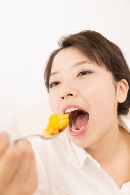 Güzel Japon kadın evde yemek yiyor.