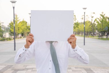 Sokakta boş kağıtları olan genç adam. 