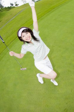 Genç mutlu kadın golf oynuyor.