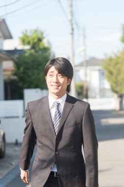 Şehirde yürüyen Asyalı genç bir işadamının portresi.