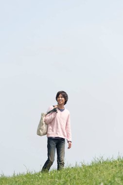 Genç adam tarlada yürüyor.