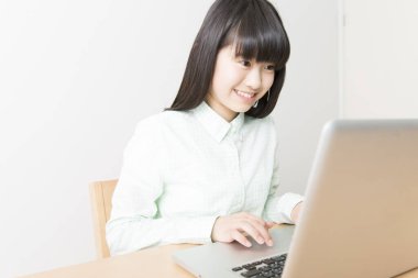 Evde dizüstü bilgisayar kullanan öğrenci kız.