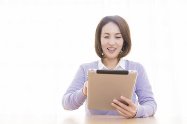 Tablet kullanan güzel Asyalı kadın.