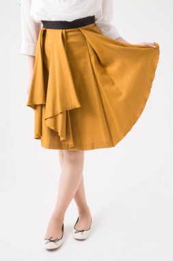 Kahverengi etek ve beyaz gömlek giyen genç bir kadın.