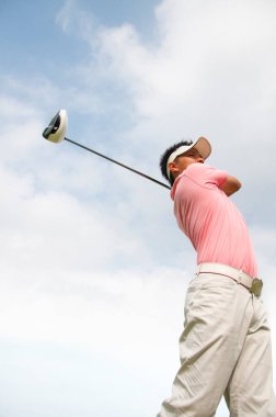 Güneşli bir sabahta golf oynayan bir golfçü. 