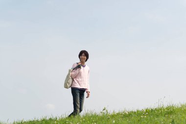 Çayırdaki çantalı genç adam.