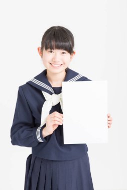 Okul üniformalı güzel bir öğrencinin portresi beyaz arka planda boş bir poster tutuyor.