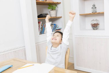 Mutlu Asyalı çocuk ellerini kaldırıyor. 