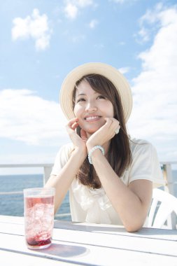 Sahilde limonata içen bir kadın.