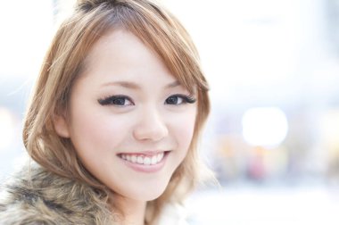 Güzel stil sahibi Asyalı kadın şehir caddesinde poz veriyor.