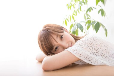 Evdeki masadaki genç Japon kadın. 