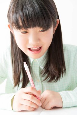 Asyalı öğrenci sınıfta yazıyor. 