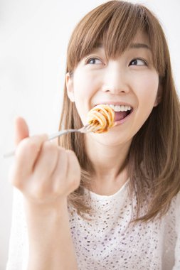 Evde spagettisi olan güzel bir Japon kadın.